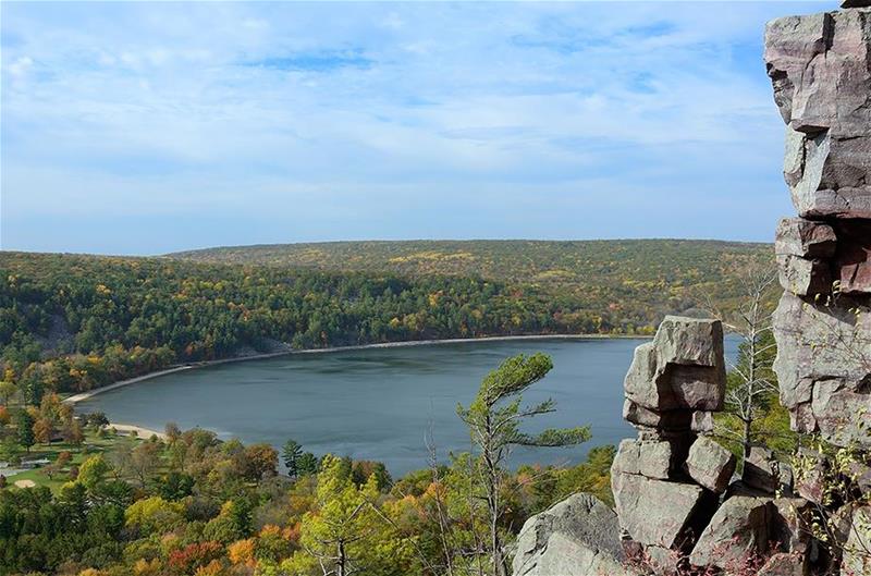 A view of a lake from nearby rocky cliffs