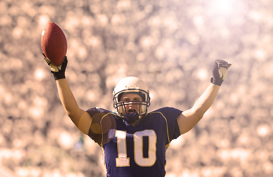 A football player holding a football in the air