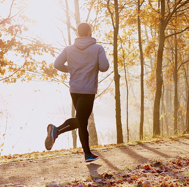 A man jogging on a wooded path