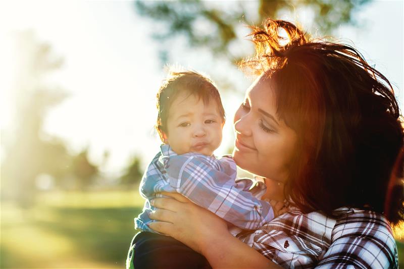 A woman holding a baby outside