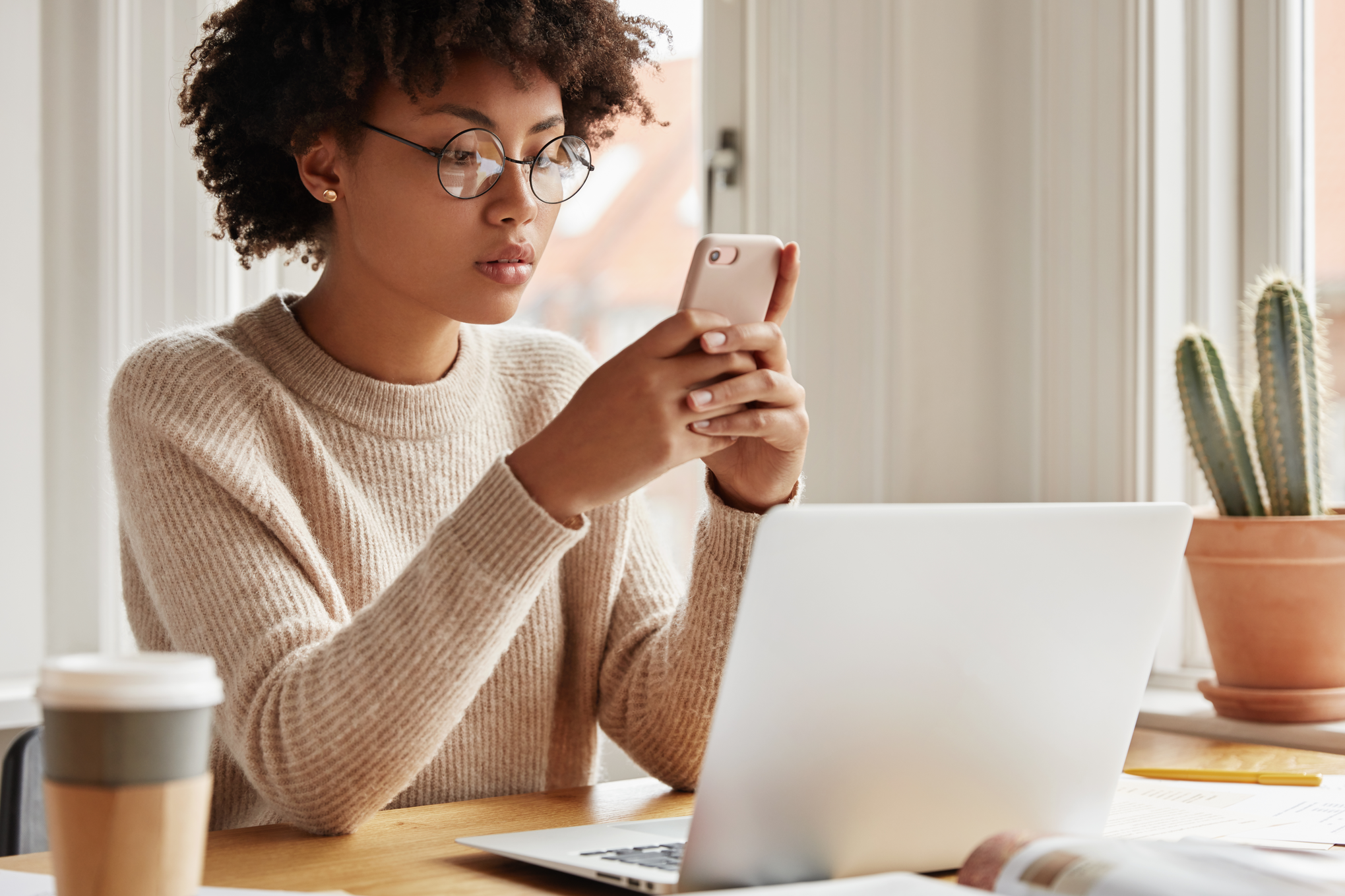 A woman using a smartphone at a desk