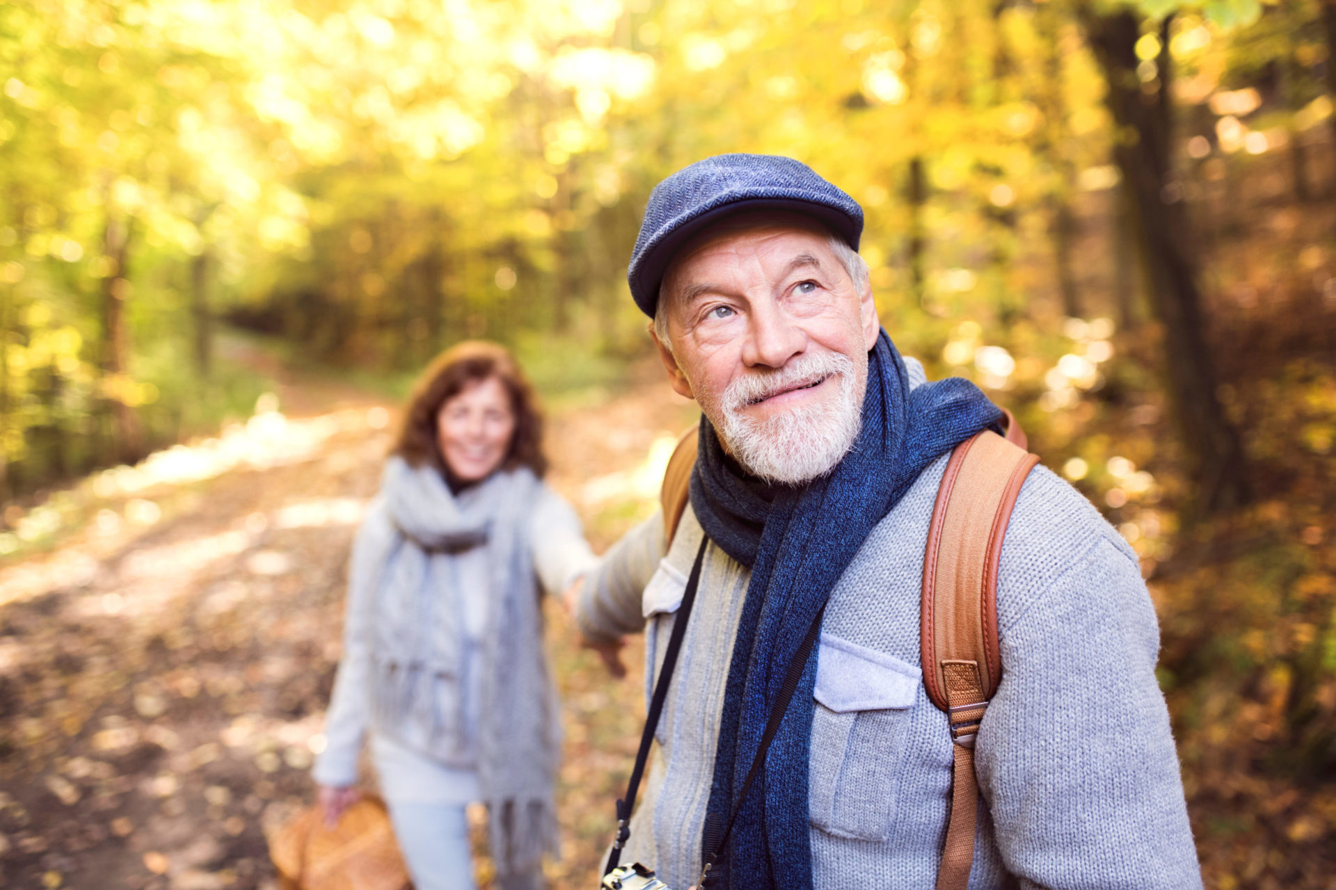 An older couple hiking in the fall woods