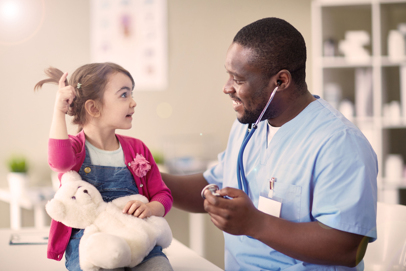 Little girl holding a teddy bear at the doctor's office