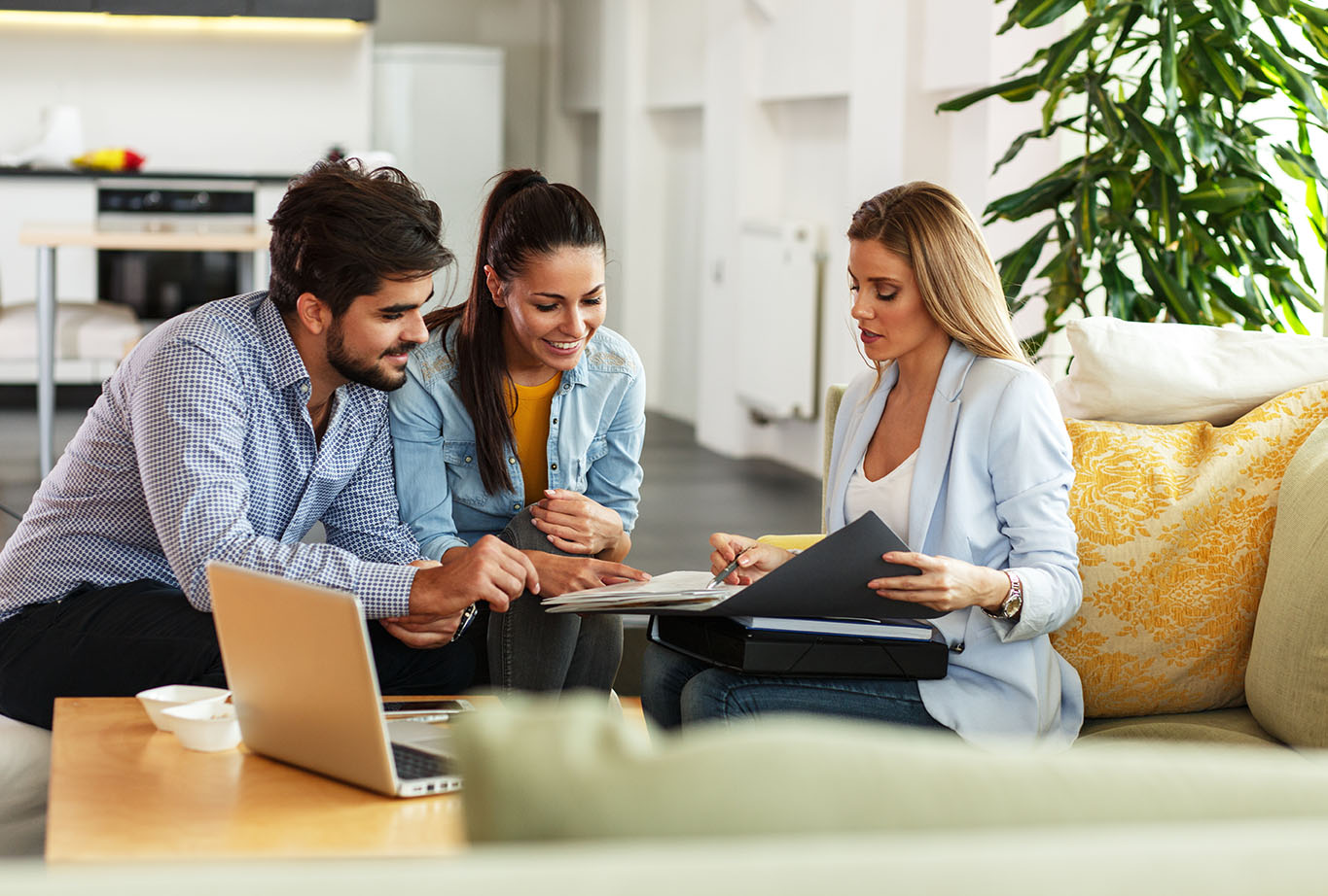 A woman goes over paperwork with a young couple