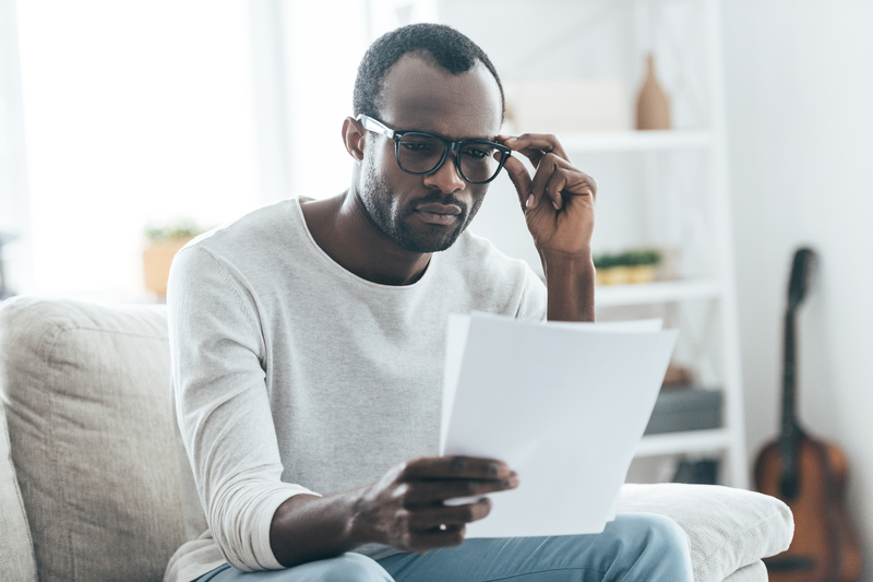 A man studying a couple of documents in his hand