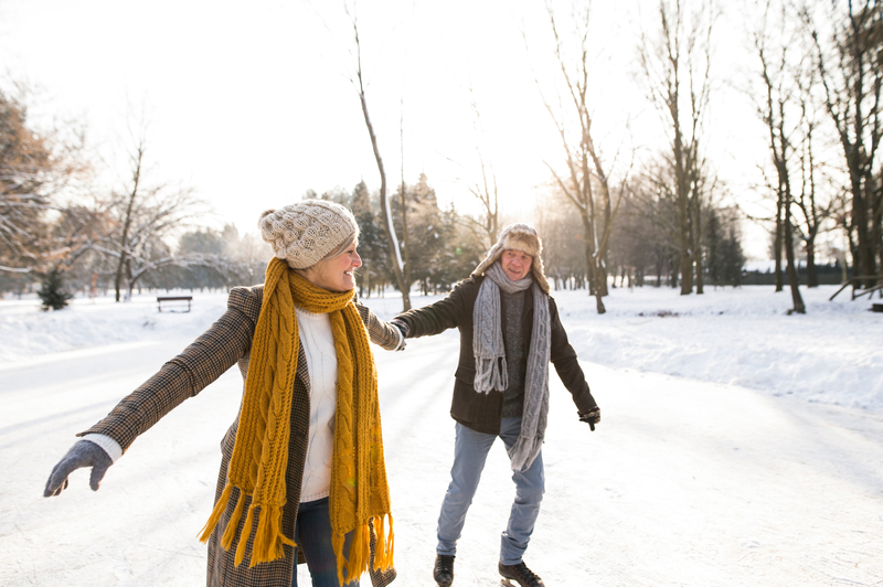 Adult couple holding hands ice skating together