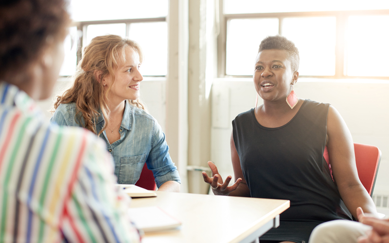 A group of women talking around a table