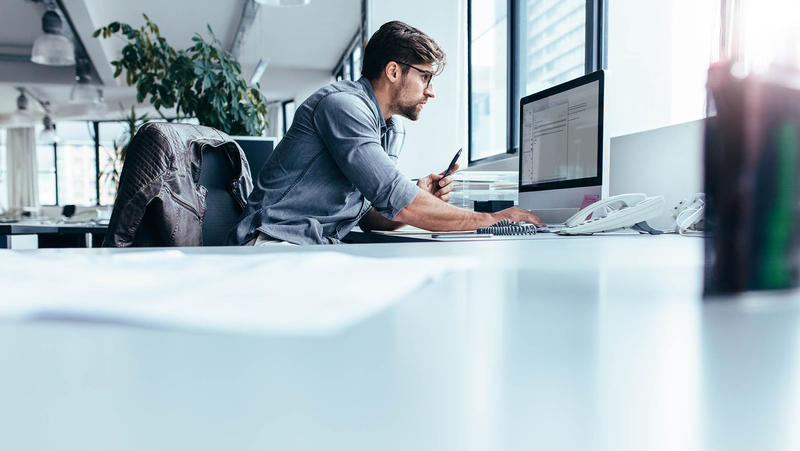 A man at his desk working on a computer