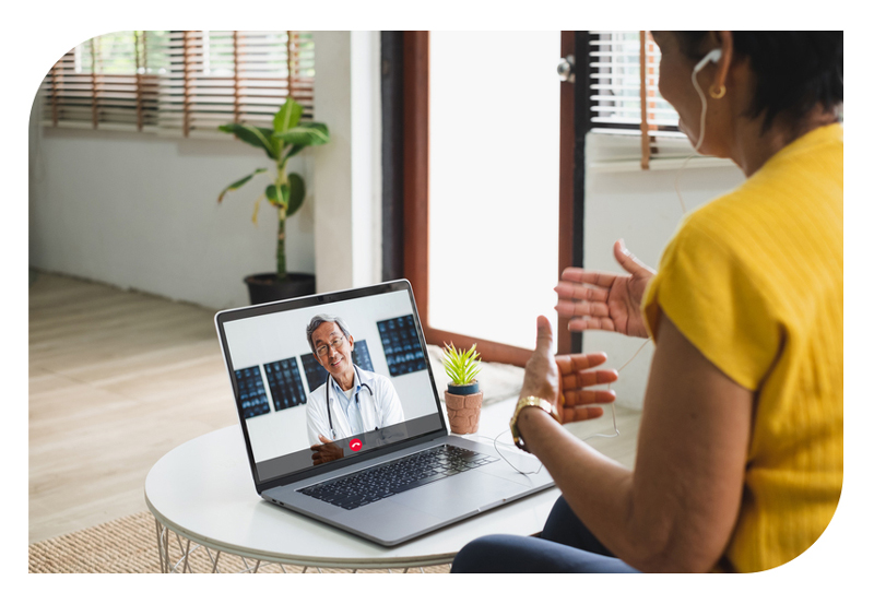 A woman on a virtual call with doctor on a laptop