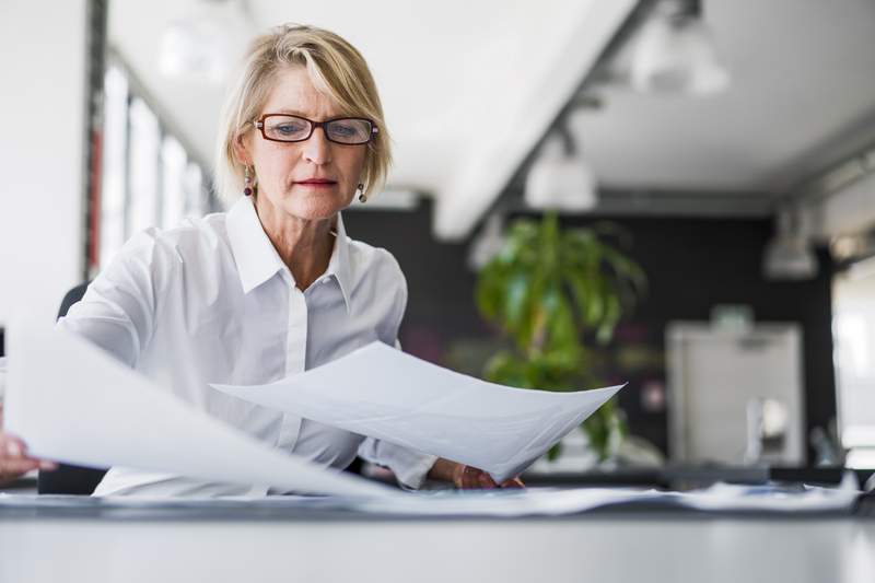 A woman reviewing documents at her desk