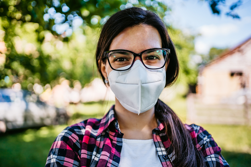 A woman wearing a mask while outdoors