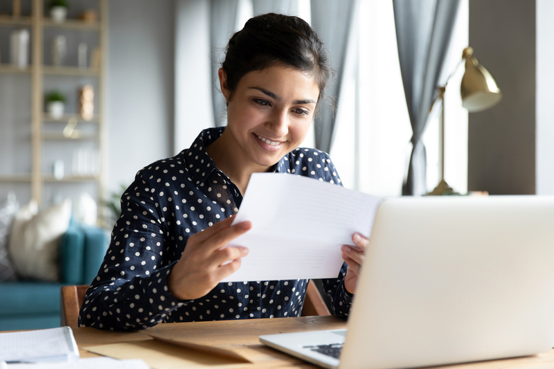 A woman reads a document at her desk