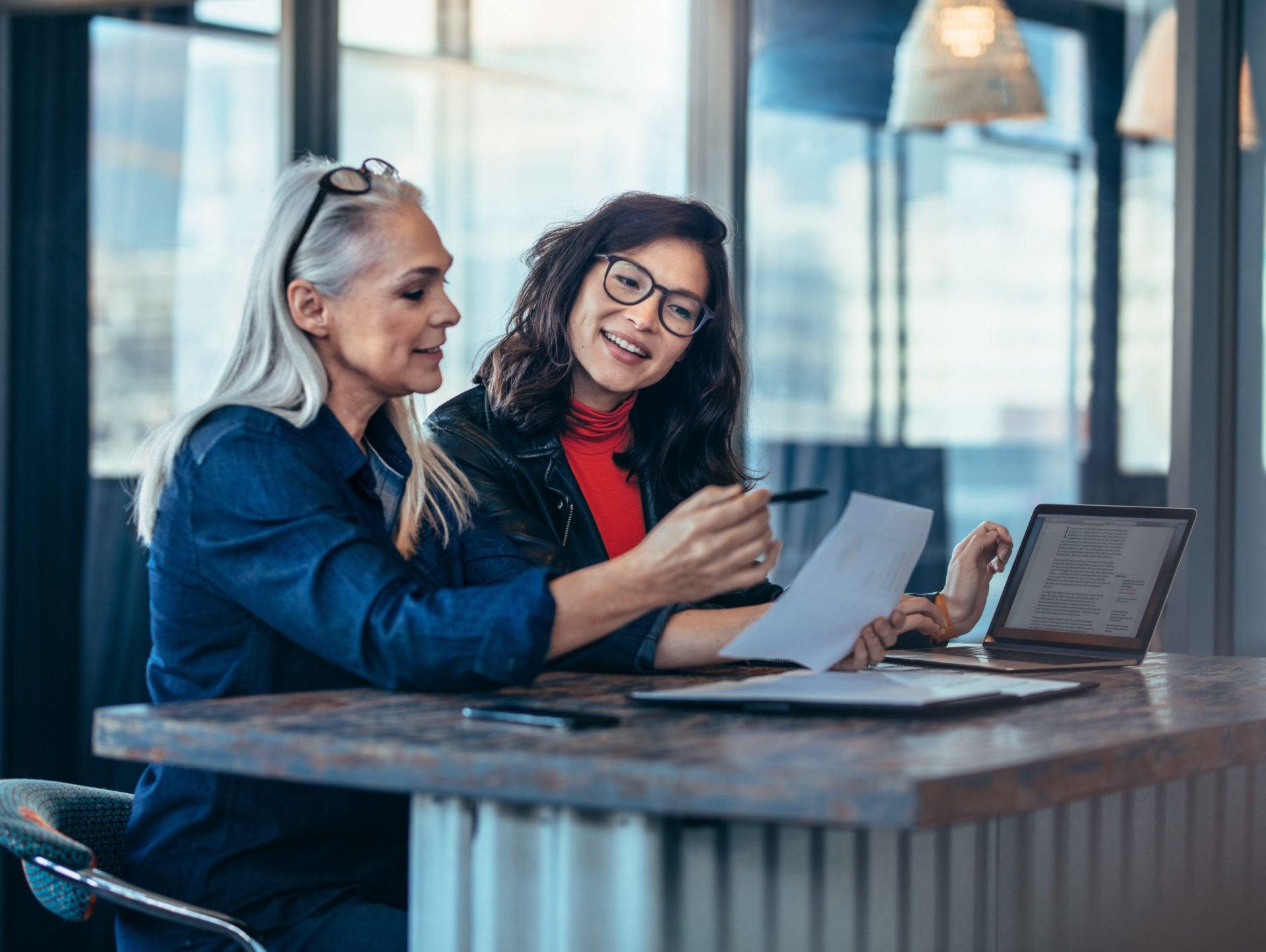 2 Women discussing work ideas at a table