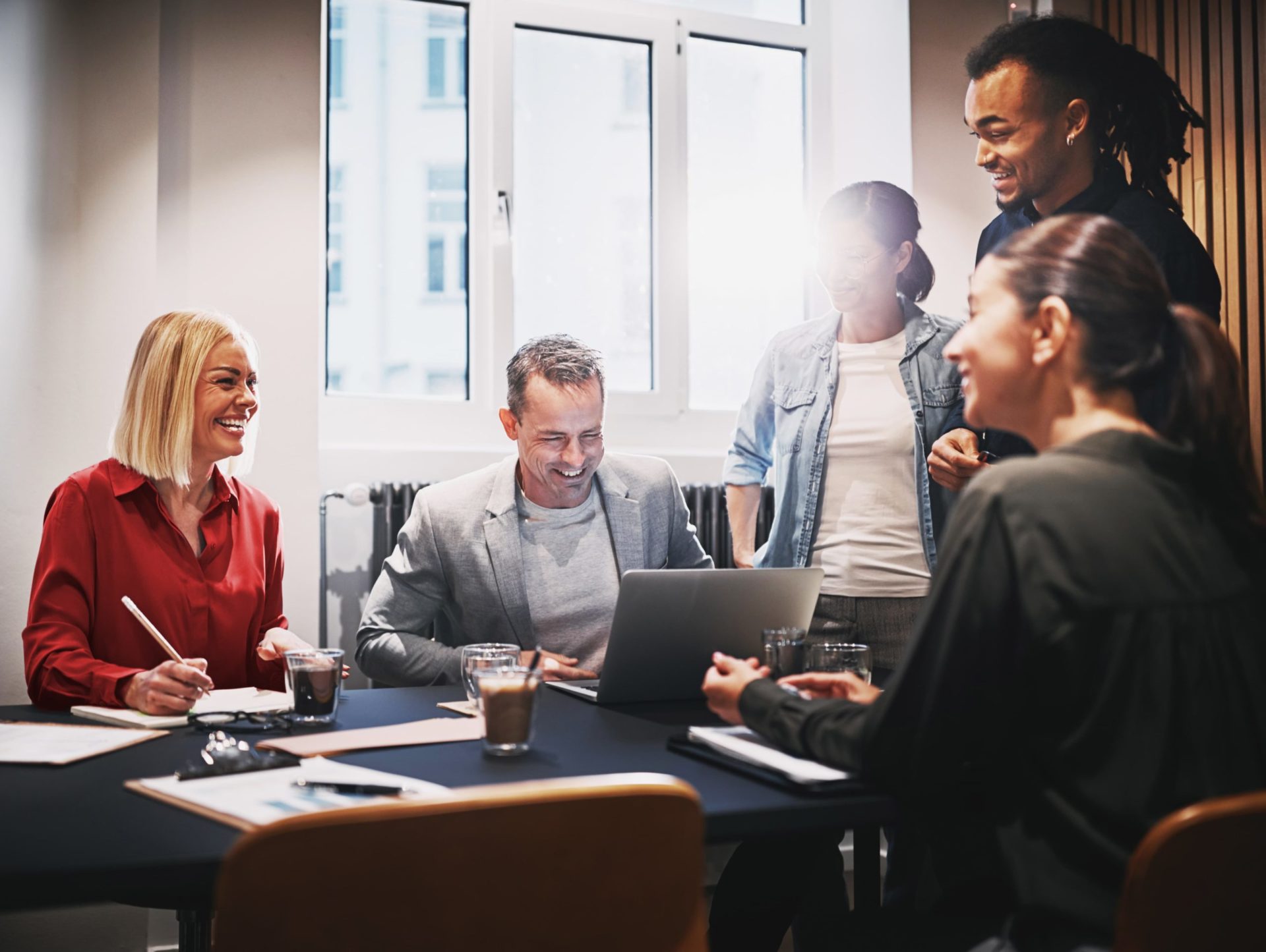 A group of people laughing and smiling in a meeting room