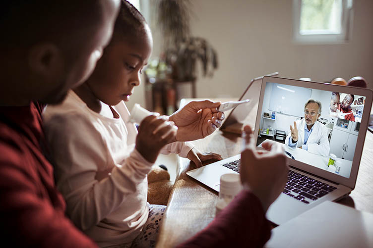 A father and daughter having a video call virtual visit with their doctor