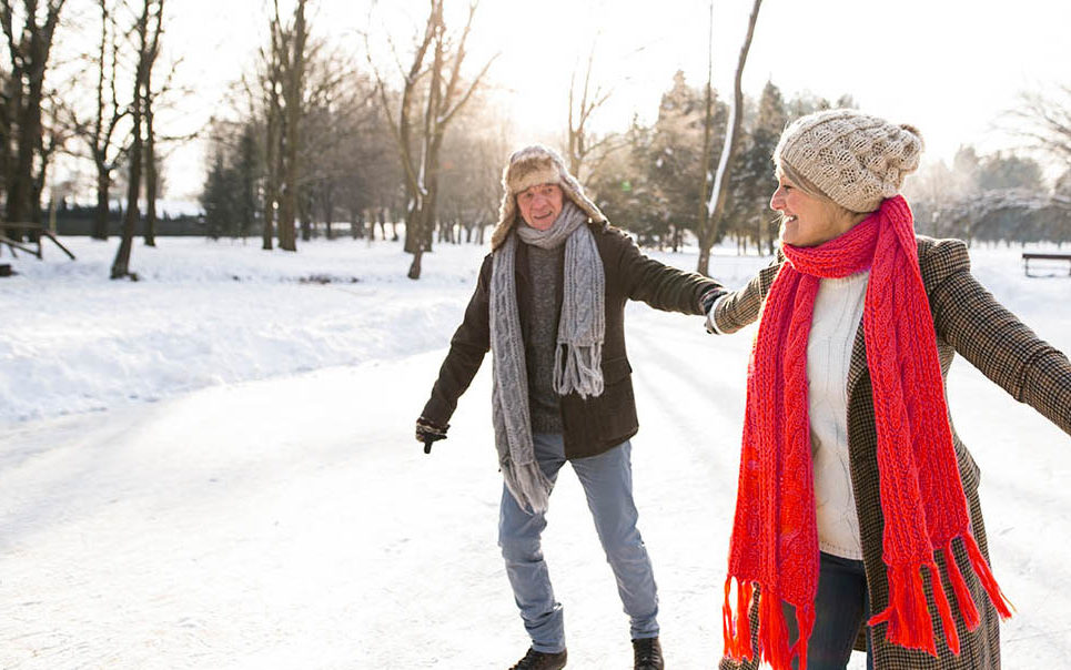 A senior couple ice skating on a pond