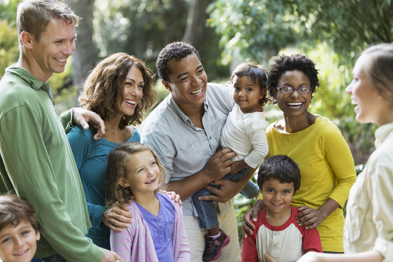 A diverse group at a park talking with a tour guide