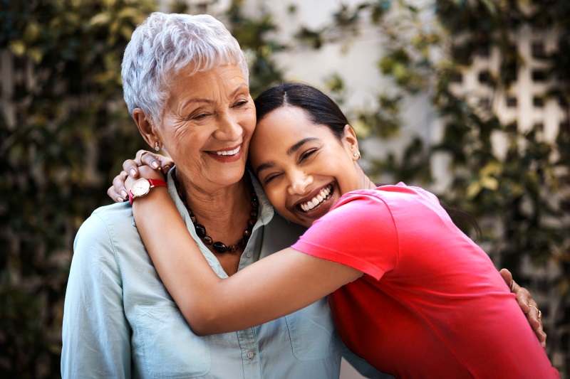 A woman hugs an elderly woman