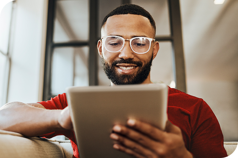 A man sitting on a couch using a tablet