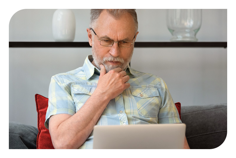 A senior man using a laptop at home