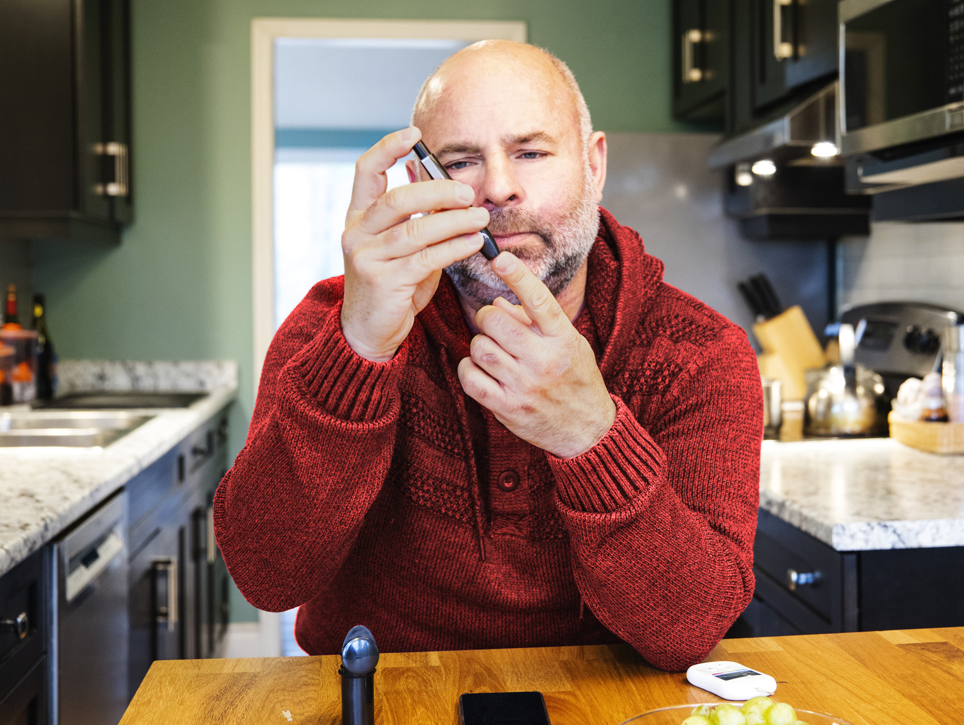 A man checking his blood sugar in a house